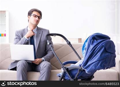 Businessman looking after newborn baby at home and teleworking