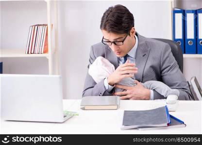 Businessman looking after newborn baby in office