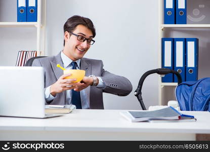 Businessman looking after newborn baby in office