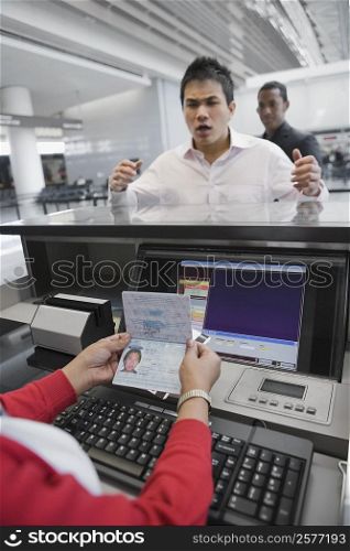 Businessman looking angry at a ticket counter in an airport