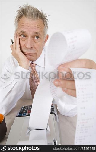 Businessman Looking at Calculator Paper