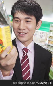 Businessman looking at can in the Supermarket