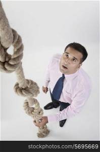 Businessman looking at rope