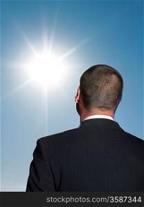 Businessman looking at sun head and shoulders back view