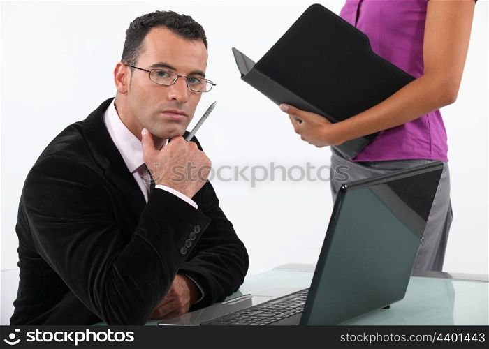businessman looking earnest with secretary by his side