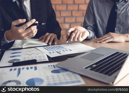 Businessman looking graph and summary report on document finance budget paper with analysis cost data result.