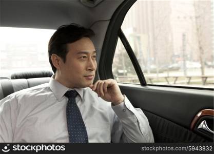Businessman looking out car window