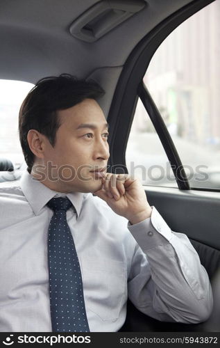 Businessman looking out car window