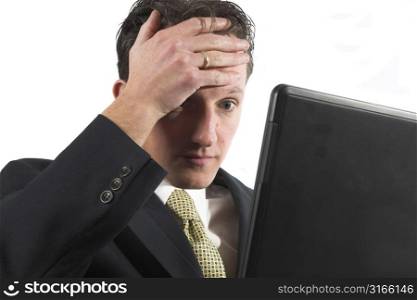 Businessman looking shocked while looking at his computer
