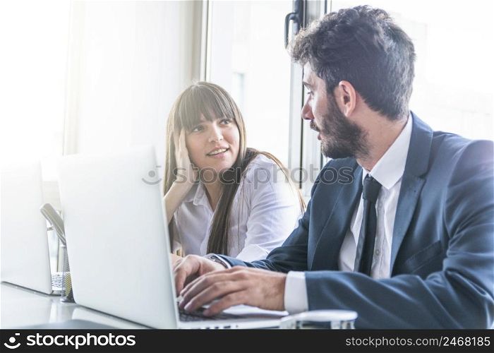 businessman looking smiling young woman using laptop