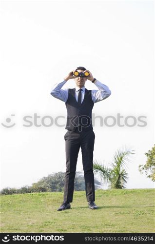 Businessman looking through binoculars , INDIA , DELHI