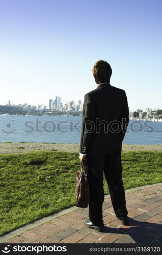 Businessman looking towards downtown buildings