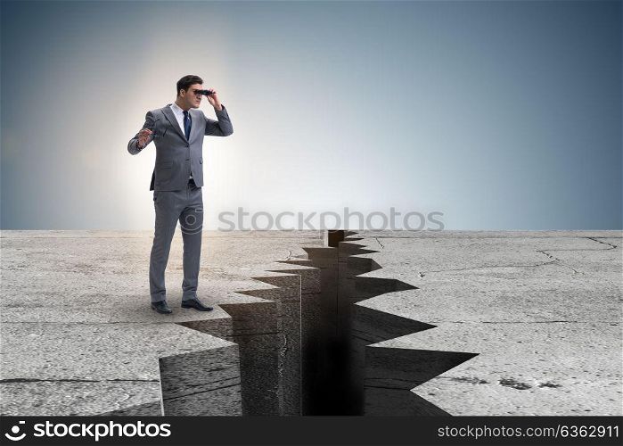 Businessman looking with binoculars at cliff edge