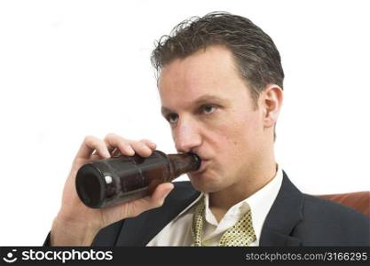 Businessman lurking on his bottle of beer while clearly having had enough