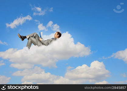 Businessman lying on clouds