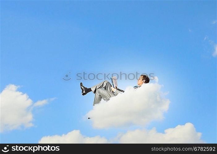 Businessman lying on clouds