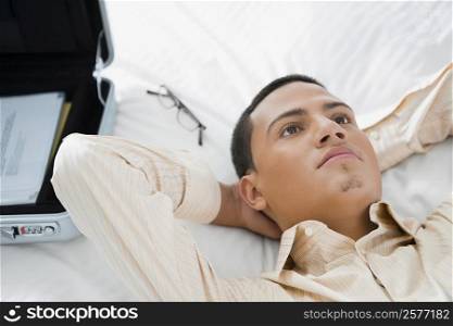 Businessman lying on the bed and thinking