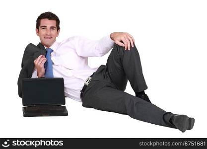 Businessman lying on the floor with his laptop