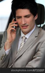 Businessman making phone call in his car