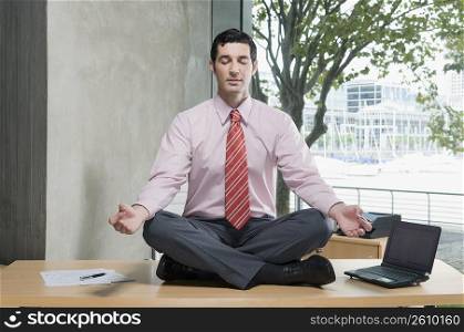 Businessman meditating in an office