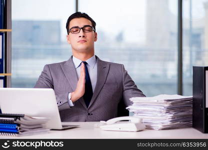 Businessman meditating in the office