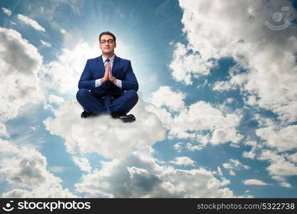 Businessman meditating in the sky