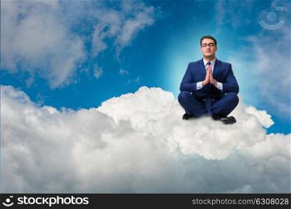 Businessman meditating in the sky