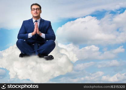 Businessman meditating in the sky