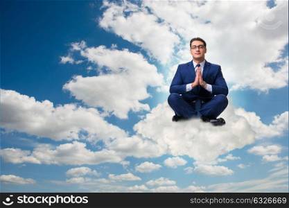 Businessman meditating in the sky