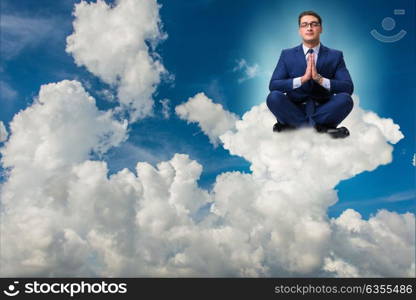 Businessman meditating in the sky