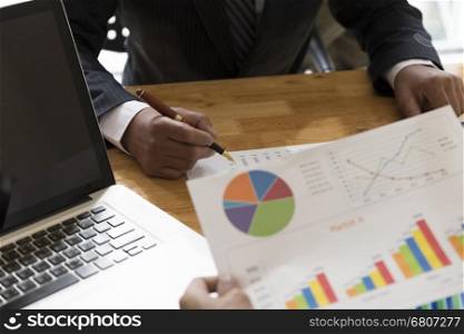 businessman meeting, analyzing and discussing with computer and paperwork document