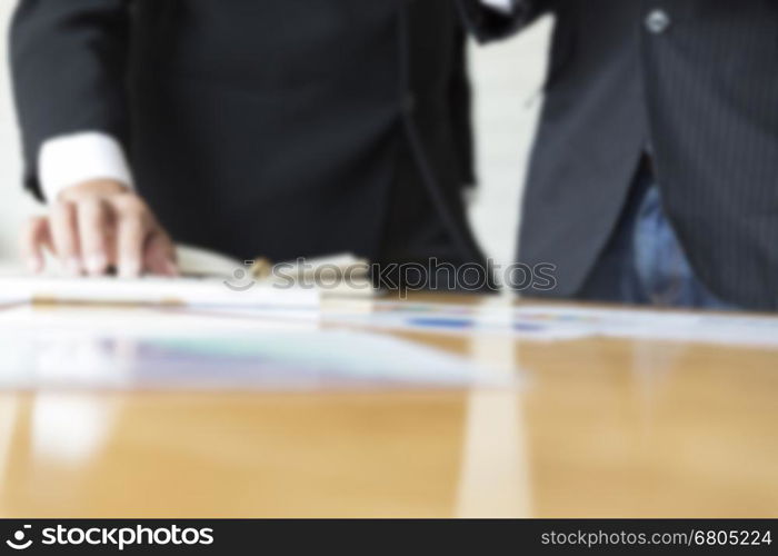businessman meeting, analyzing and discussing with computer keyboard and paperwork document- blur for use as background