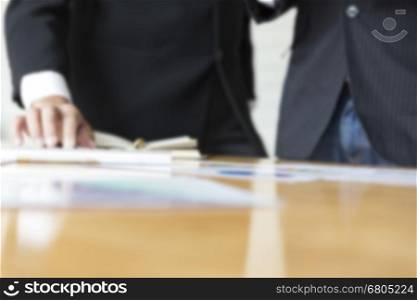 businessman meeting, analyzing and discussing with computer keyboard and paperwork document- blur for use as background