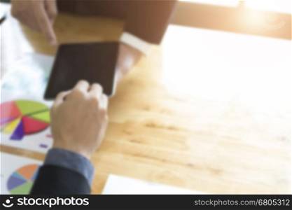 businessman meeting, analyzing and discussing with tablet and paperwork document- blur for use as background