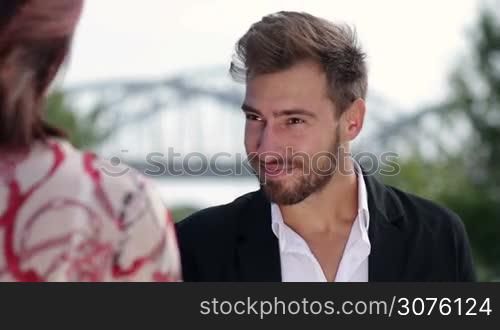 Businessman meeting his colleague outdoors and warmly greetings her with handshake