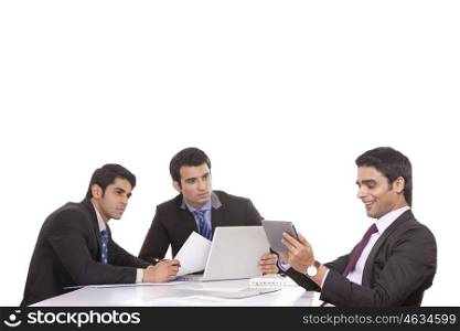 Businessman messaging as colleagues watch on