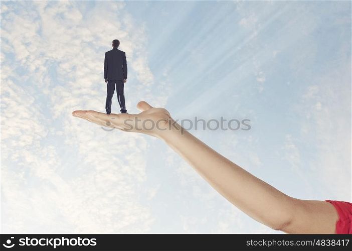 Businessman miniature in hand. Image of businessman miniature standing in hand