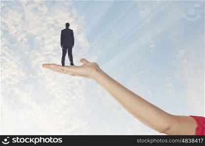 Businessman miniature in hand. Image of businessman miniature standing in hand