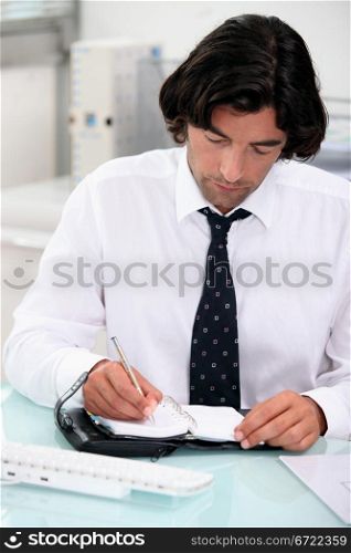 Businessman noting appointment on organizer