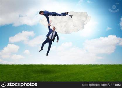 Businessman offering helping hand to falling colleague