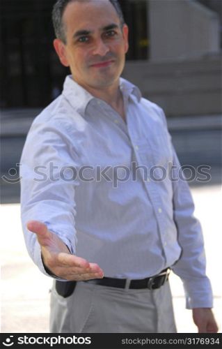 Businessman offering his hand, focus on hand