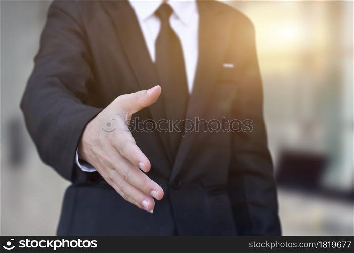 Businessman offering his hand for handshake in office. Concept of welcome for collaboration, introduction. Selective focus.