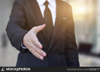 Businessman offering his hand for handshake in office. Concept of welcome for collaboration, introduction. Selective focus.