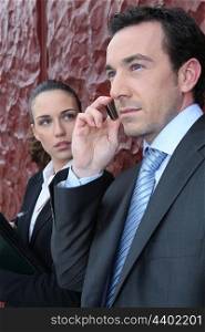 Businessman on a call whilst being watched by a colleague