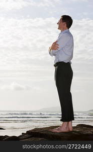 Businessman on a rock by the sea