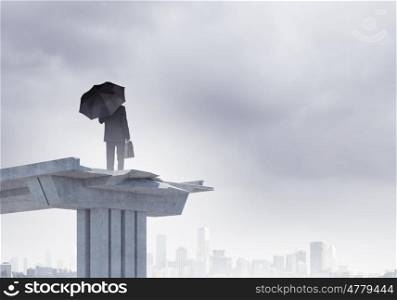 Businessman on bridge. Image of businessman with umbrella standing at the edge of bridge