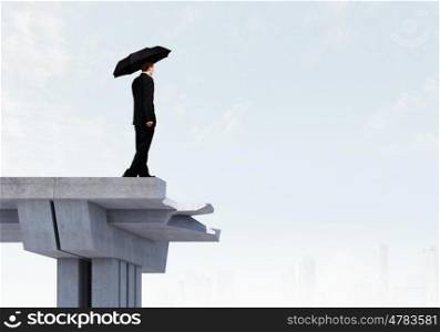 Businessman on bridge. Image of businessman with umbrella standing at the edge of bridge