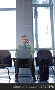 Businessman on cell phone using laptop