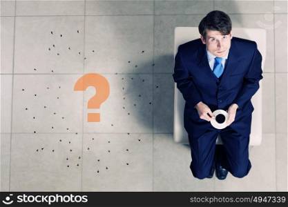 Businessman on chair. Top view of businessman with cup sitting on chair