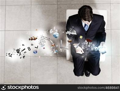 Businessman on chair. Top view of businessman with mobile phone sitting on chair